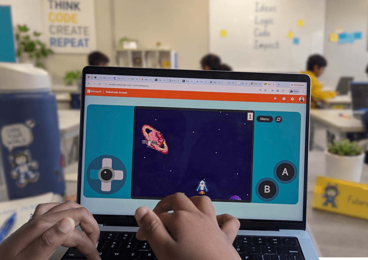 Child play-testing the arcade game they coded in Microsoft MakeCode Arcade on a laptop at a ThinkerLab coding workshop