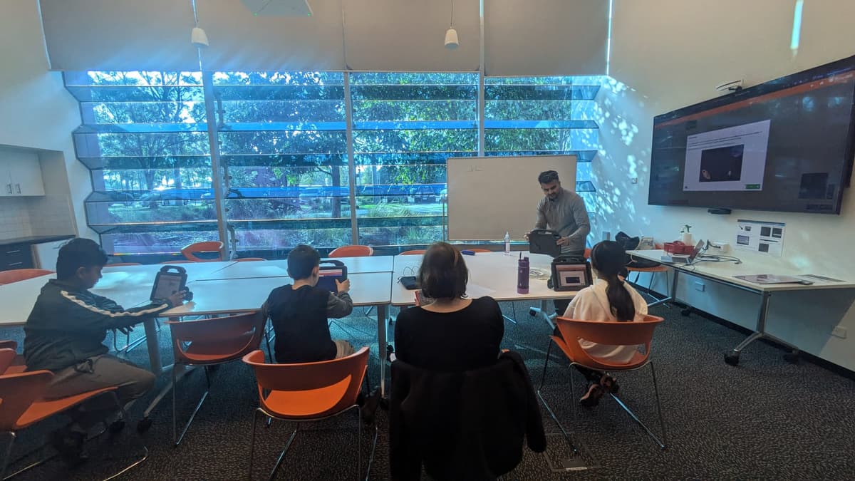 ThinkerLab instructor demonstrating a MakeCode Arcade game on screen to young coders